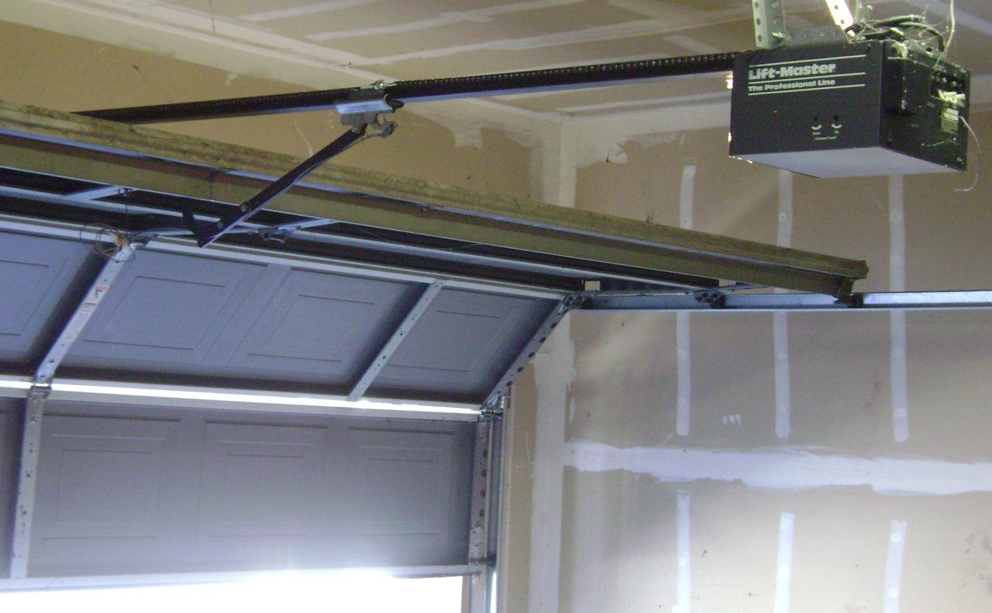 Inside view of a garage door with the opener rail and motor on the ceiling